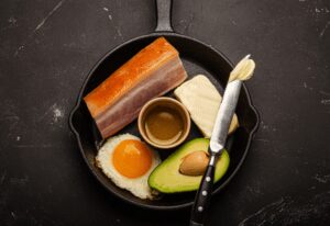 Foods for Keto Diet in Cast Iron Pan on Dark Background