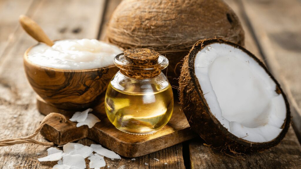 Image of fresh, whole coconuts alongside a clear glass jar filled with golden coconut oil, symbolizing natural health and wellness.