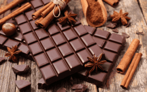 assortment of dark chocolate displayed on a charming wooden table, featuring rich chocolate bars, inviting squares, and luscious dark chocolate chips